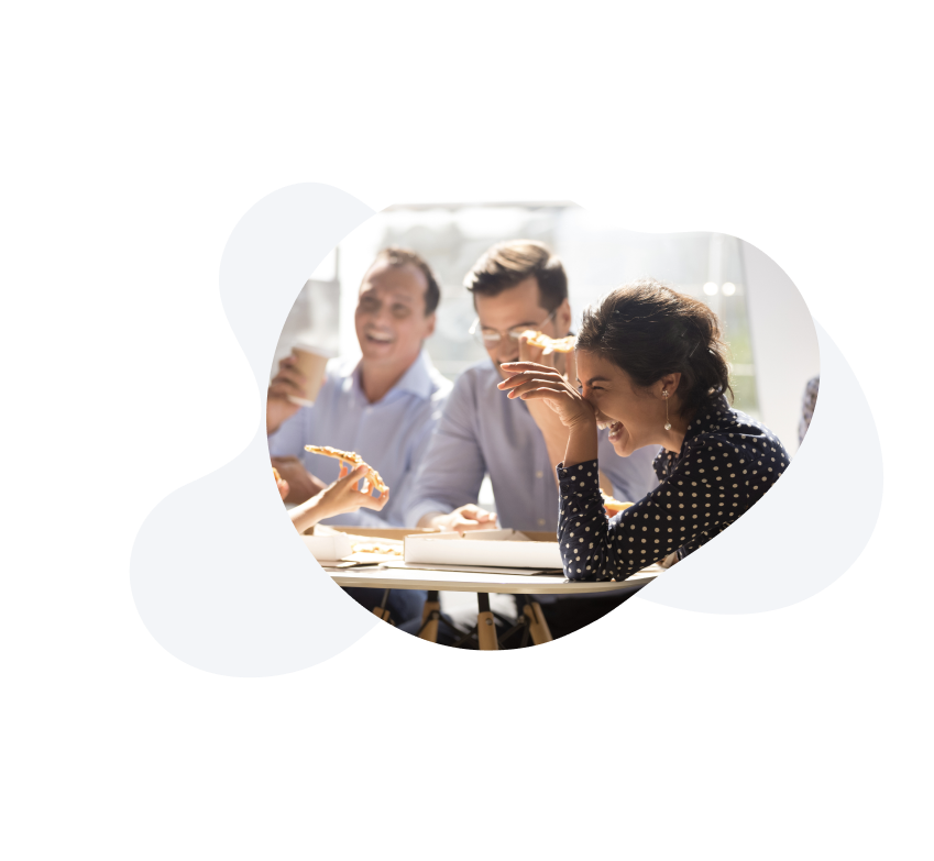 People laughing around a work meeting board table. 