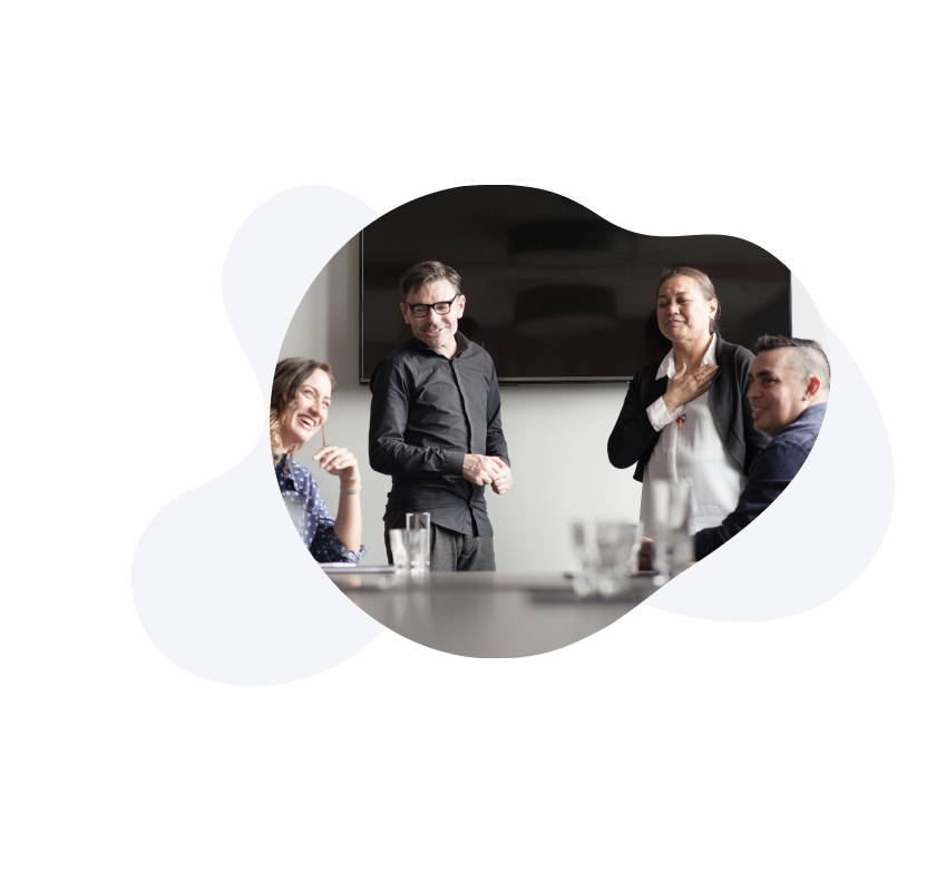 Image of a group of people in a meeting room, laughing.