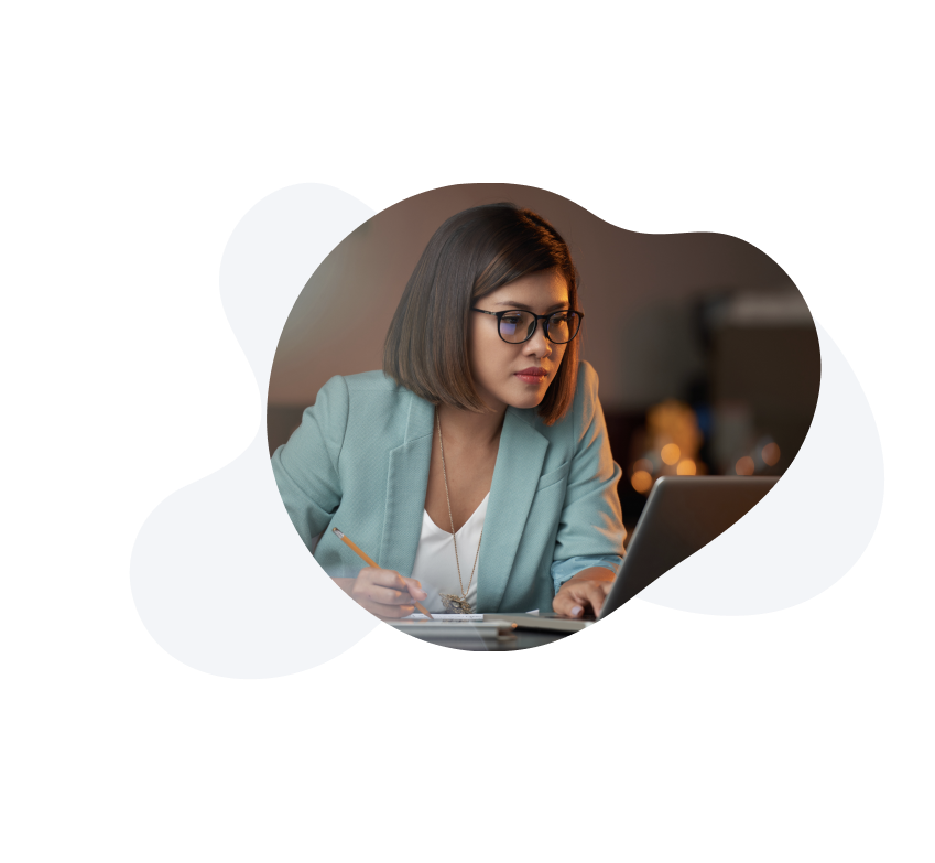 A lady in a blazer, looking at a laptop screen while planning.