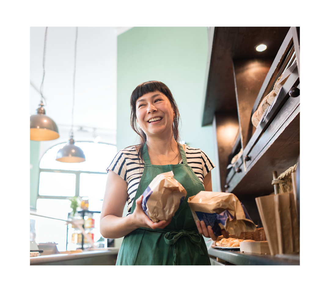 Lady smiling, holding bread