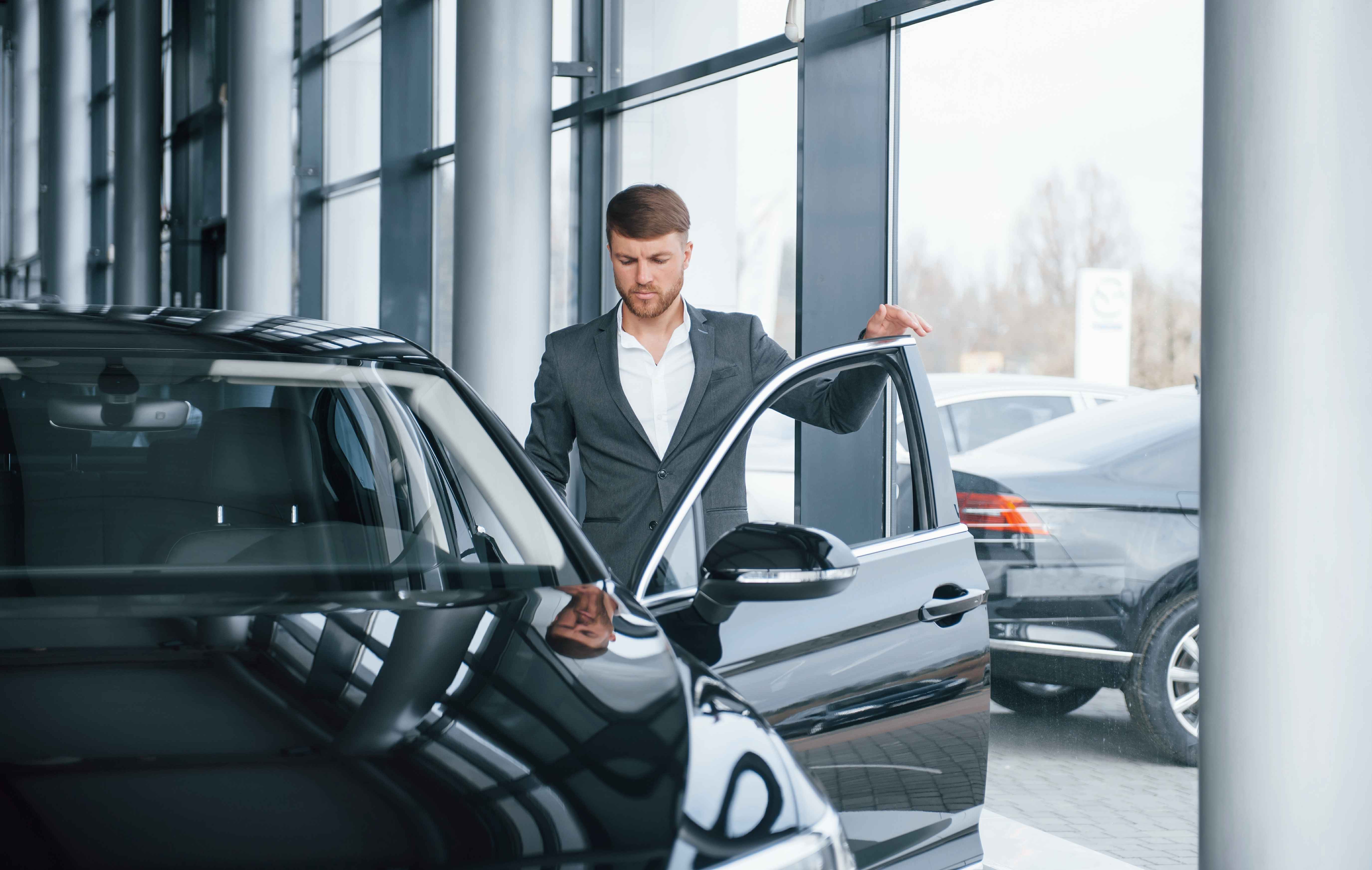 A car dealership lot displaying new and used vehicles with pricing tags, illustrating how tariffs are influencing vehicle costs in 2026. The image represents the impact of global trade policies, manufacturing locations, and supply chains on car pricing and buyer decisions.