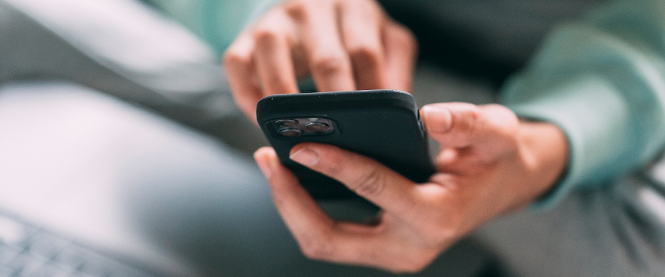 A close-up photo of a person typing on their smartphone