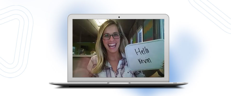 Image of a woman holding a whiteboard with recording a Covideo for a prospect named Kevin