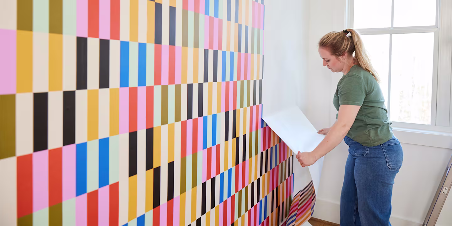 Person removing peel and stick wallpaper.
