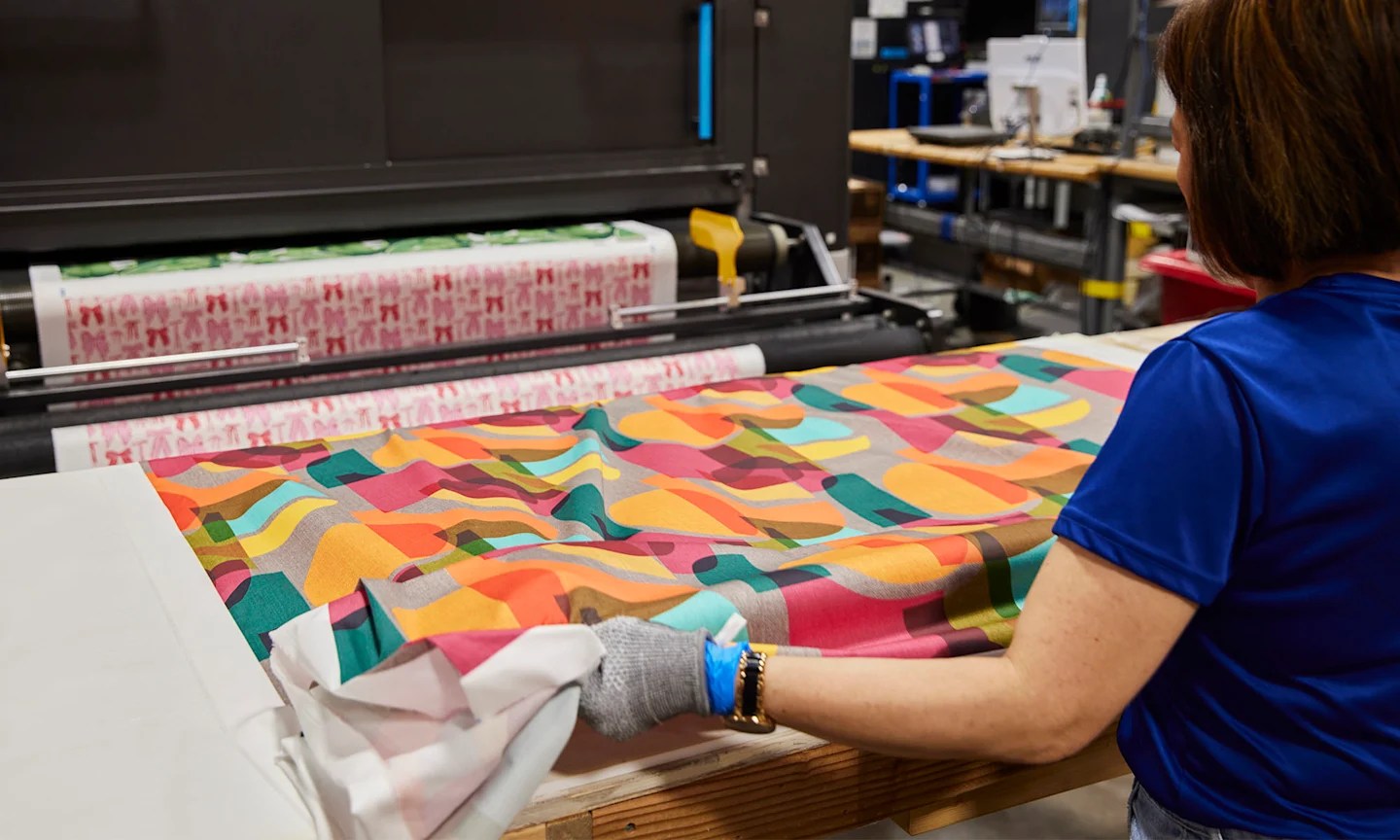 Factory workier folding fabric.