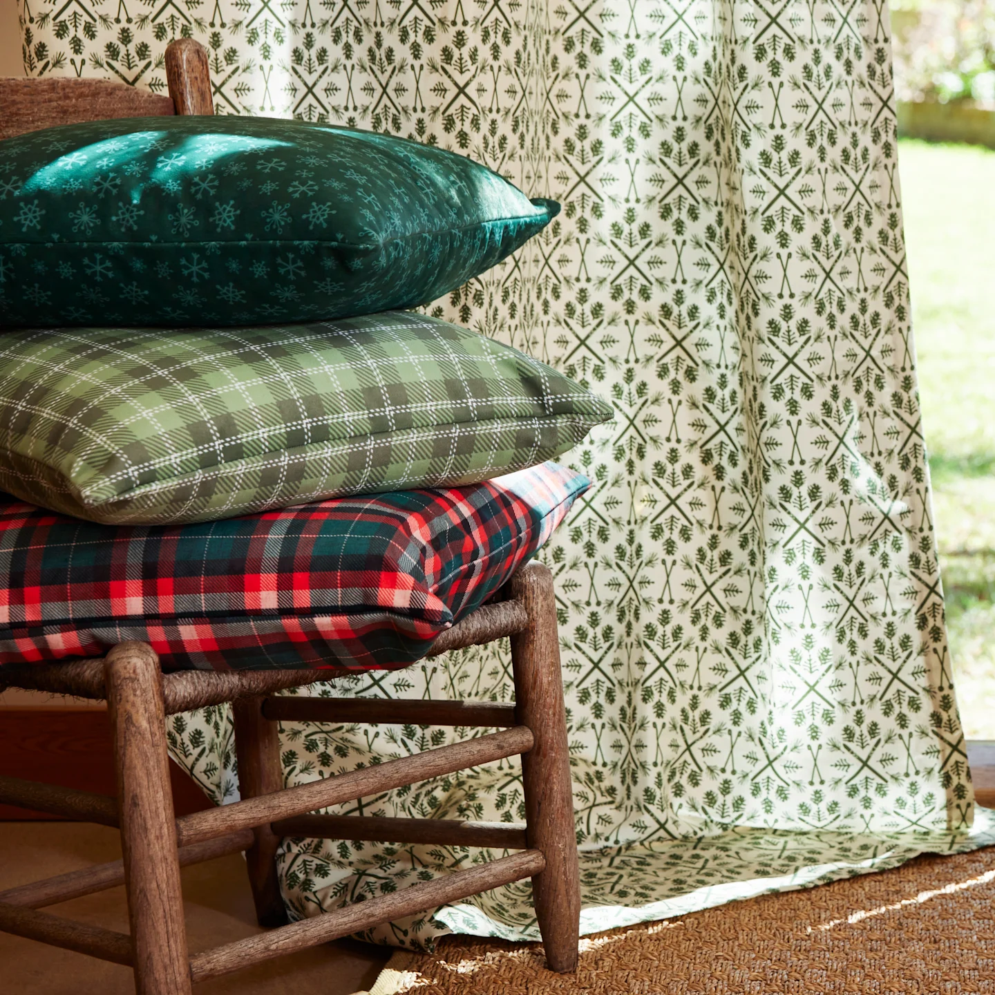 A person holding a stack of square throw pillows