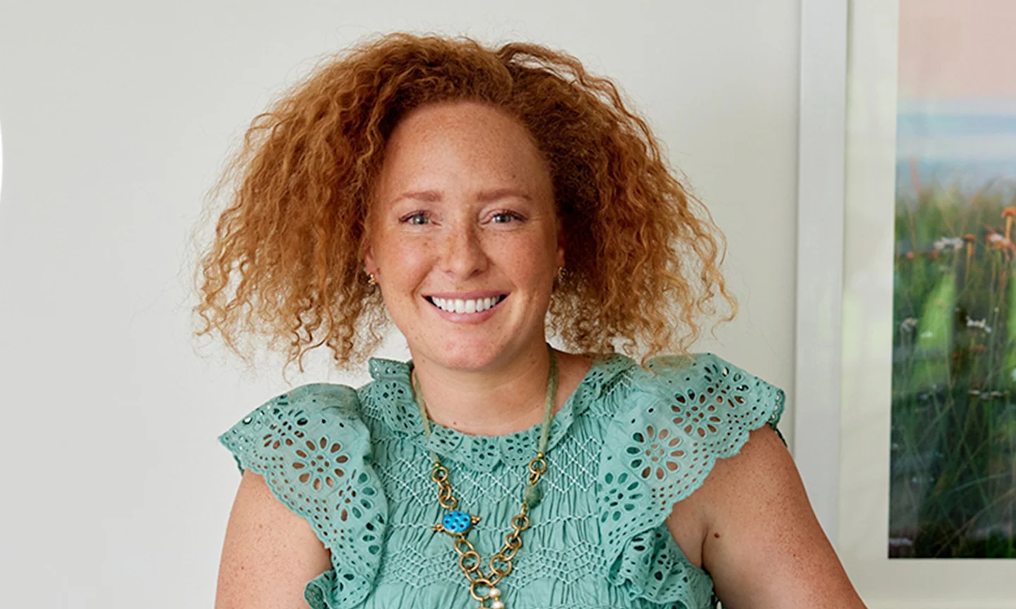 Headshot of a woman with curly red hair.