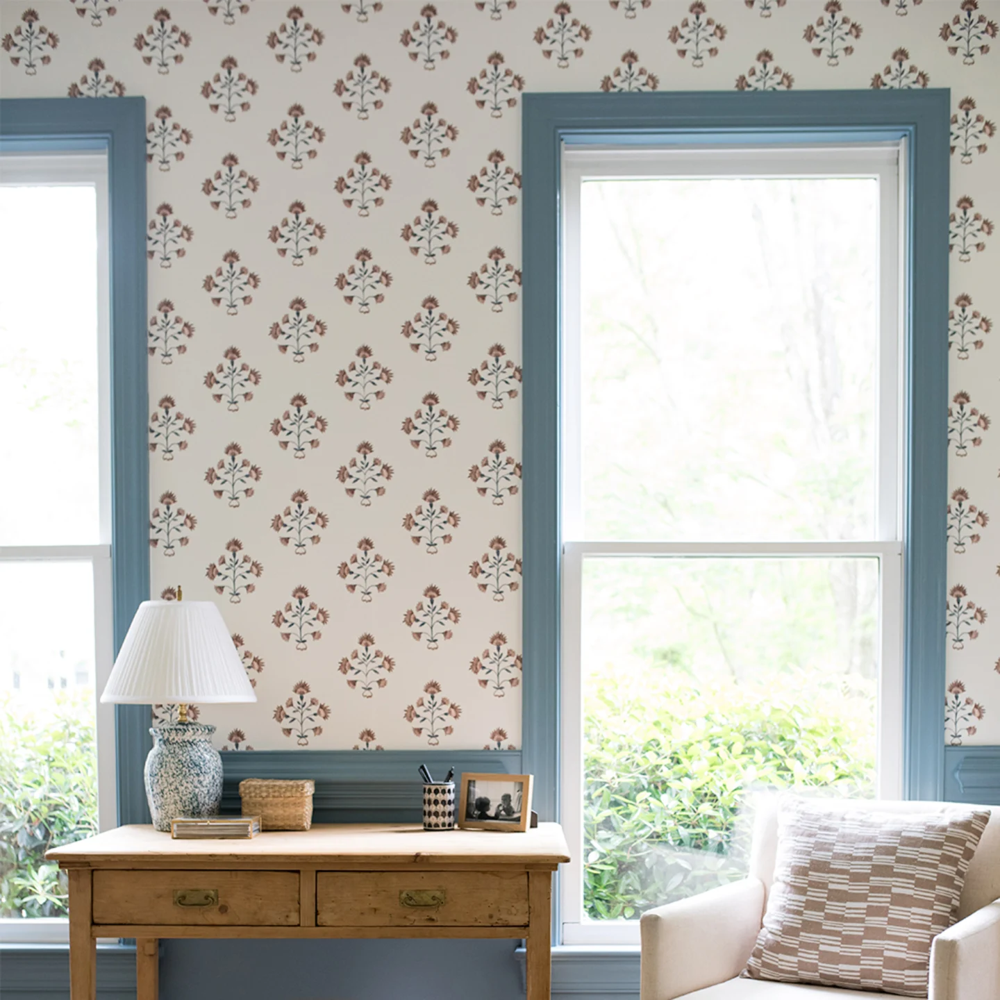 Living area with blue and rust block print style wallpaper.