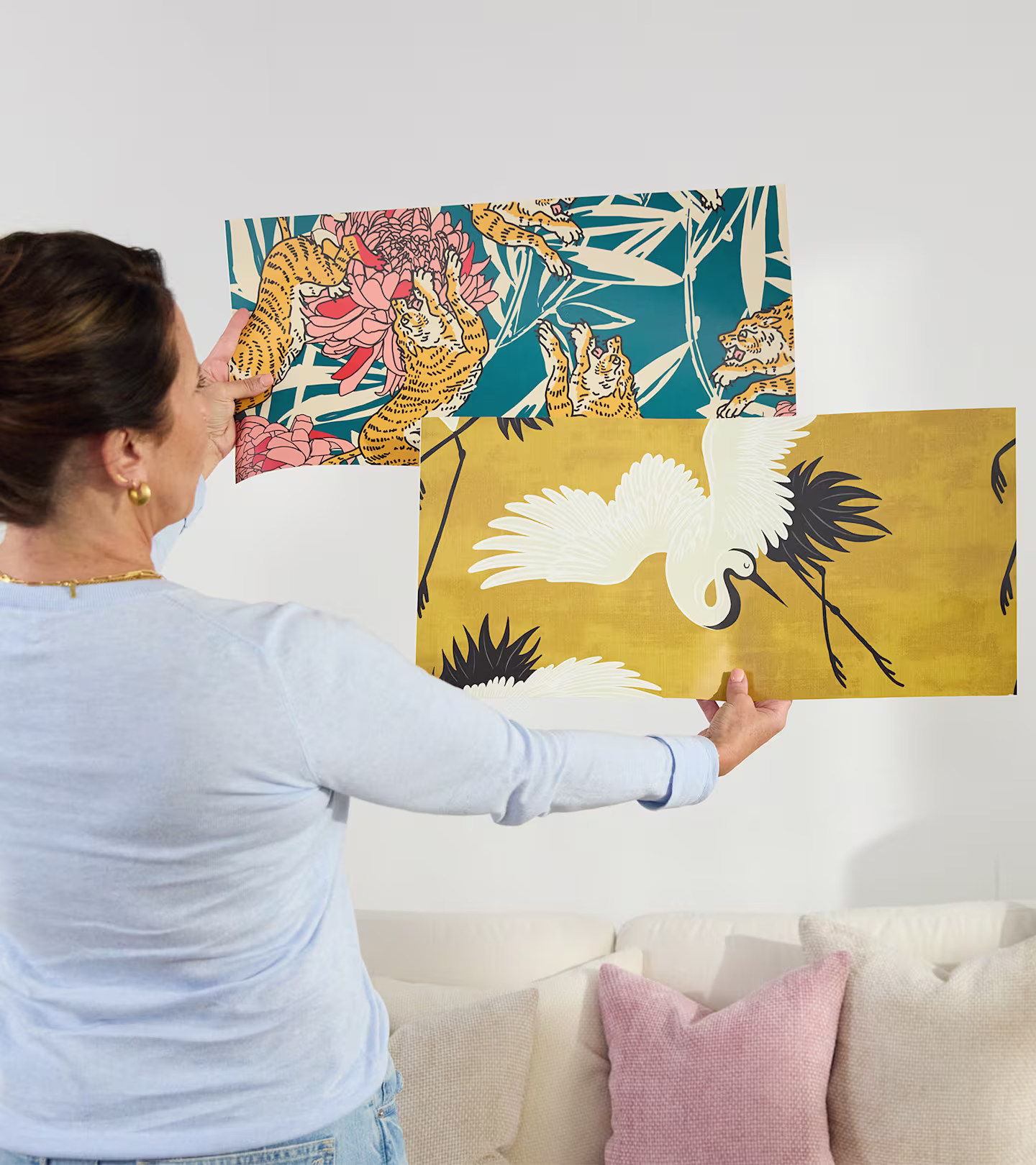 Person assessing two wallpaper samples.