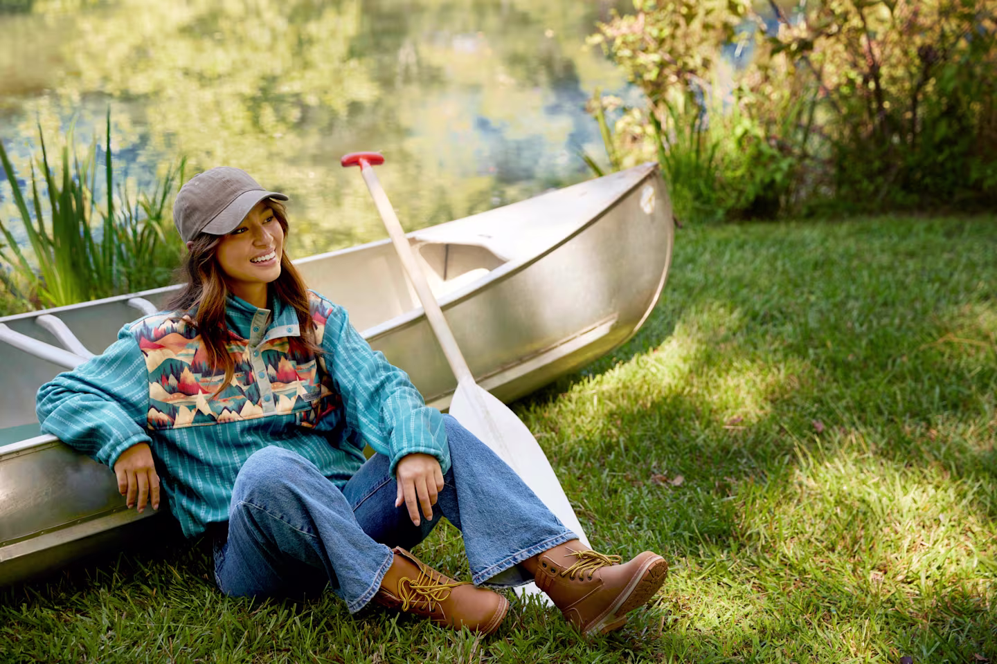 A model wearing a Polartec Fleece pullover leaning against a canoe