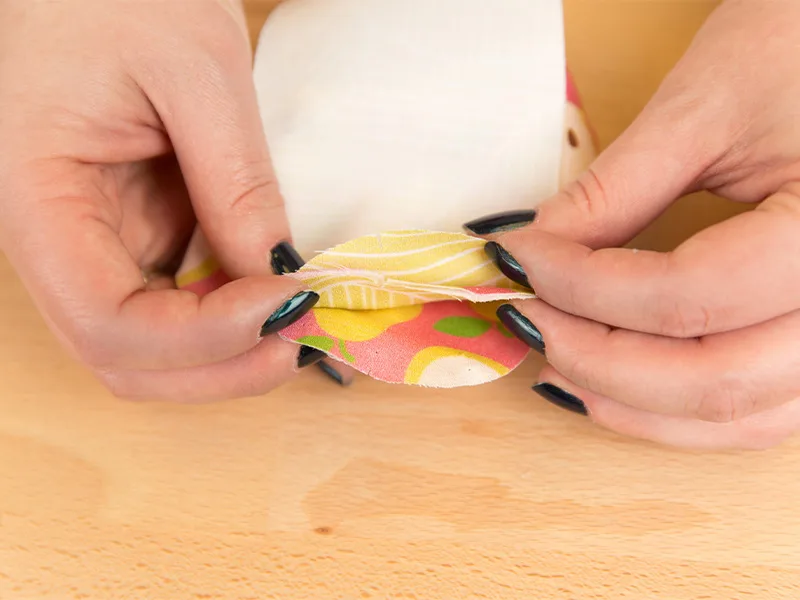 Two hands are holding the shoe bottoms pieces in an order to indicate their layers before being sewn together.