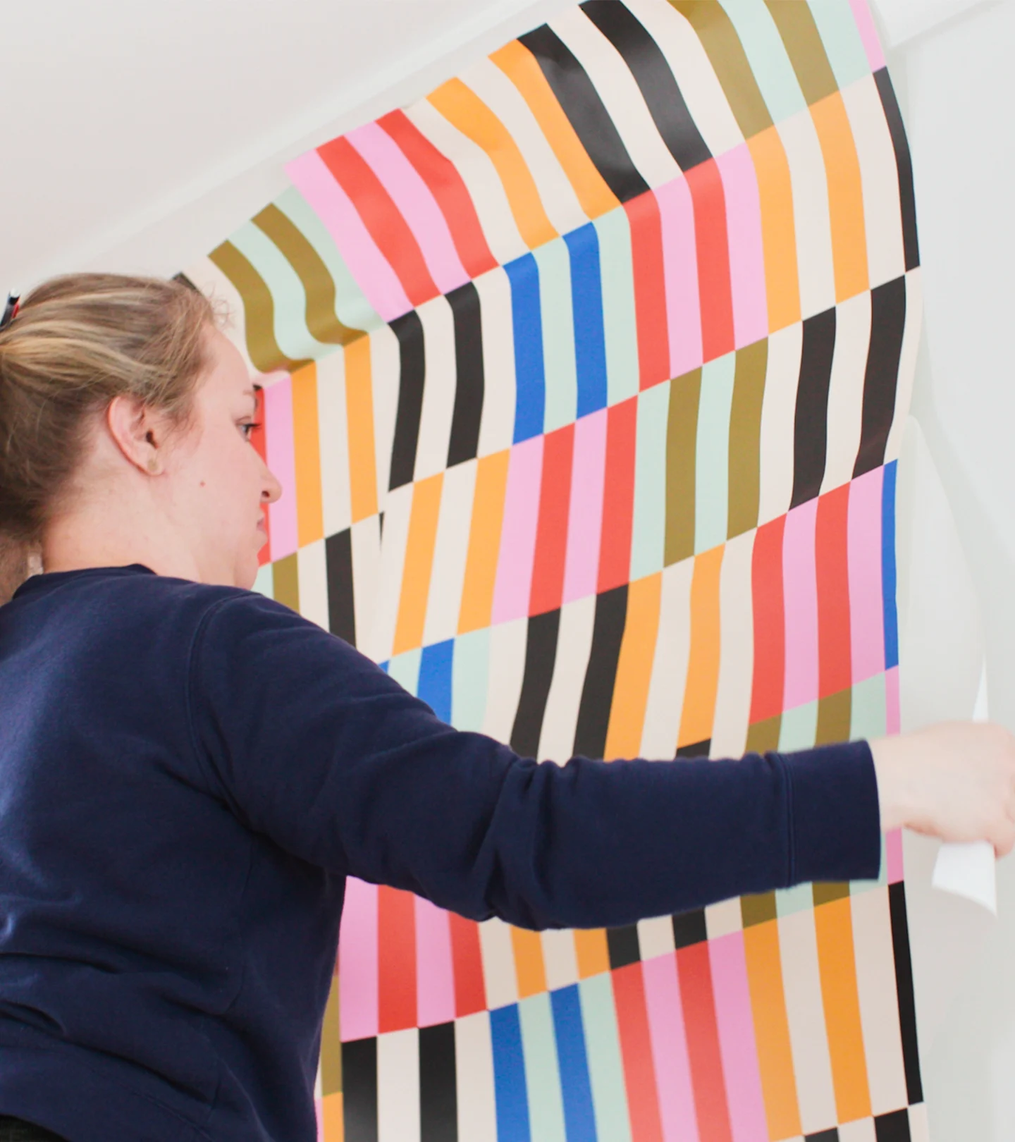 Person installing Peel and Stick wallpaper.