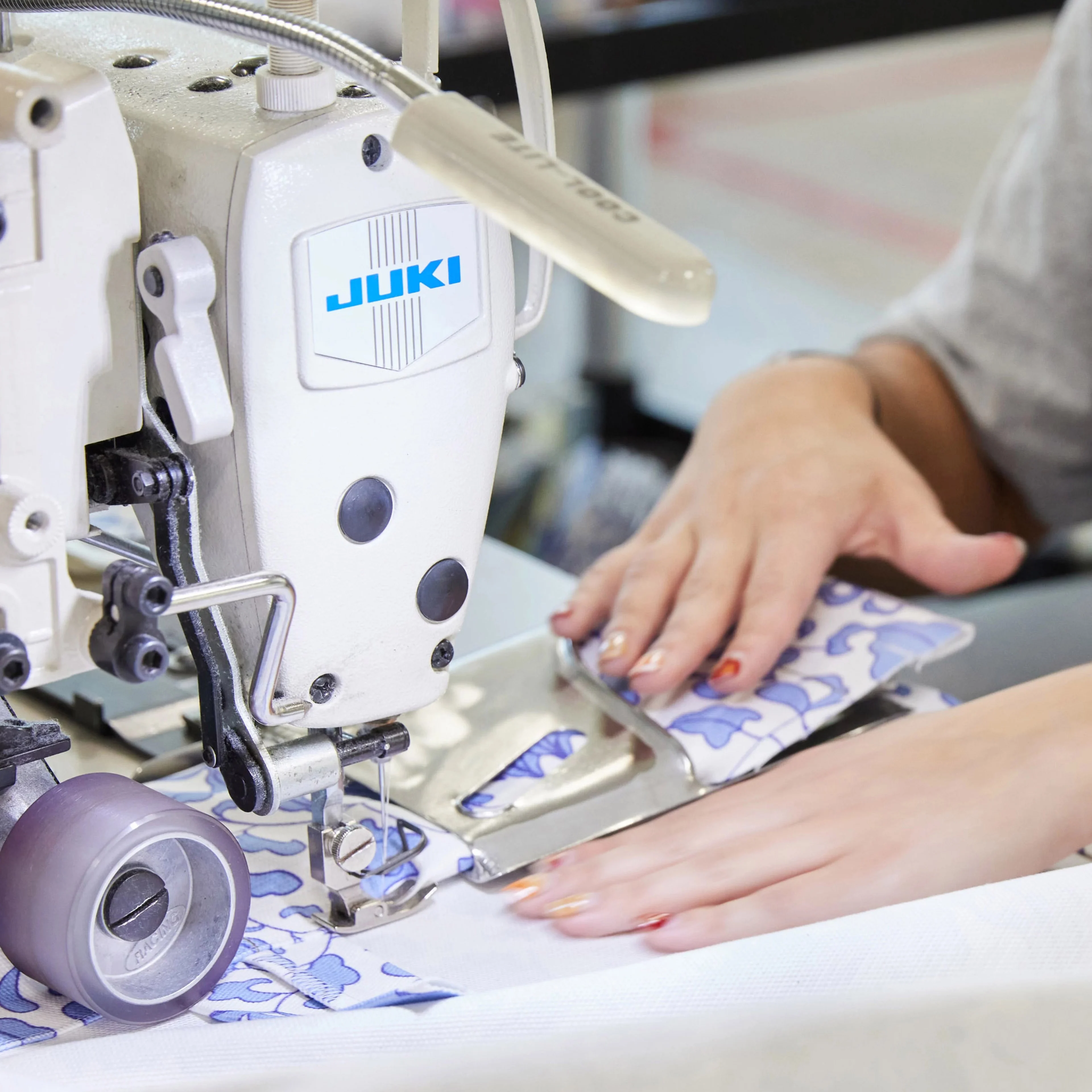 hands sewing fabric on sewing machine