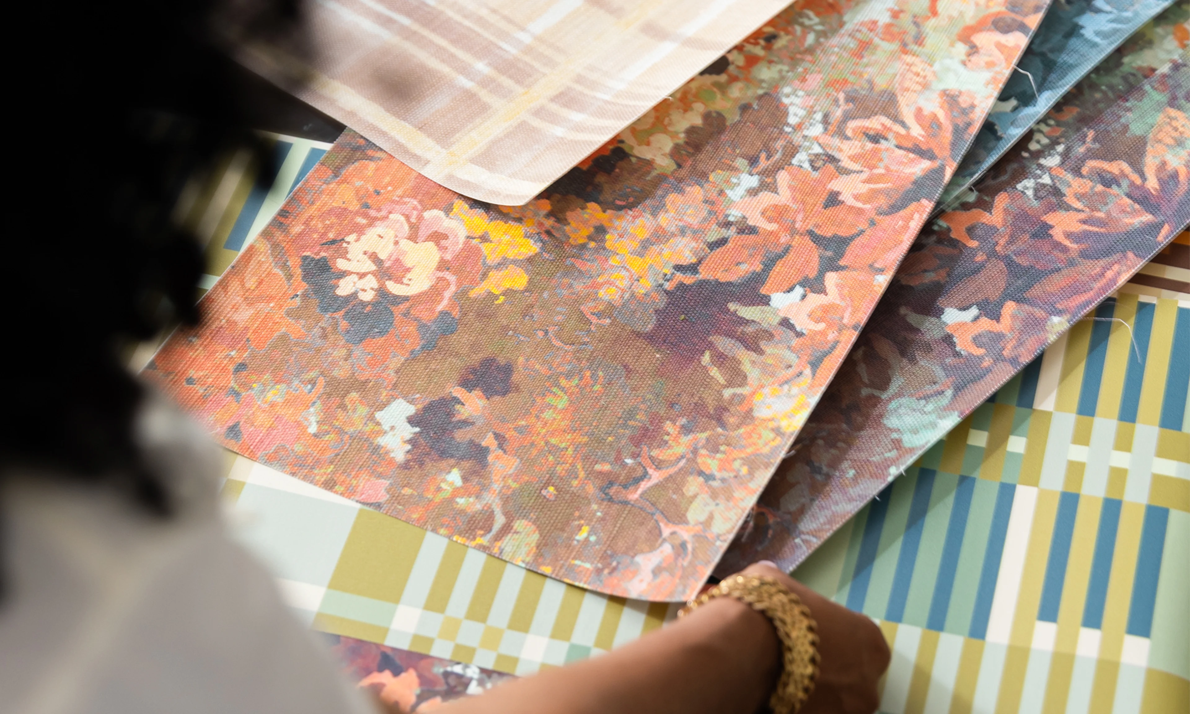 Marie Cloud of Indigo Pruitt assessing her designs on samples of Spoonflower wallpapers.