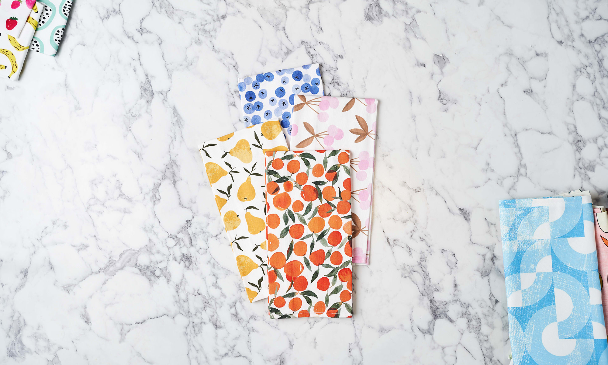 Colorful fruit-themed tea towels on counter.