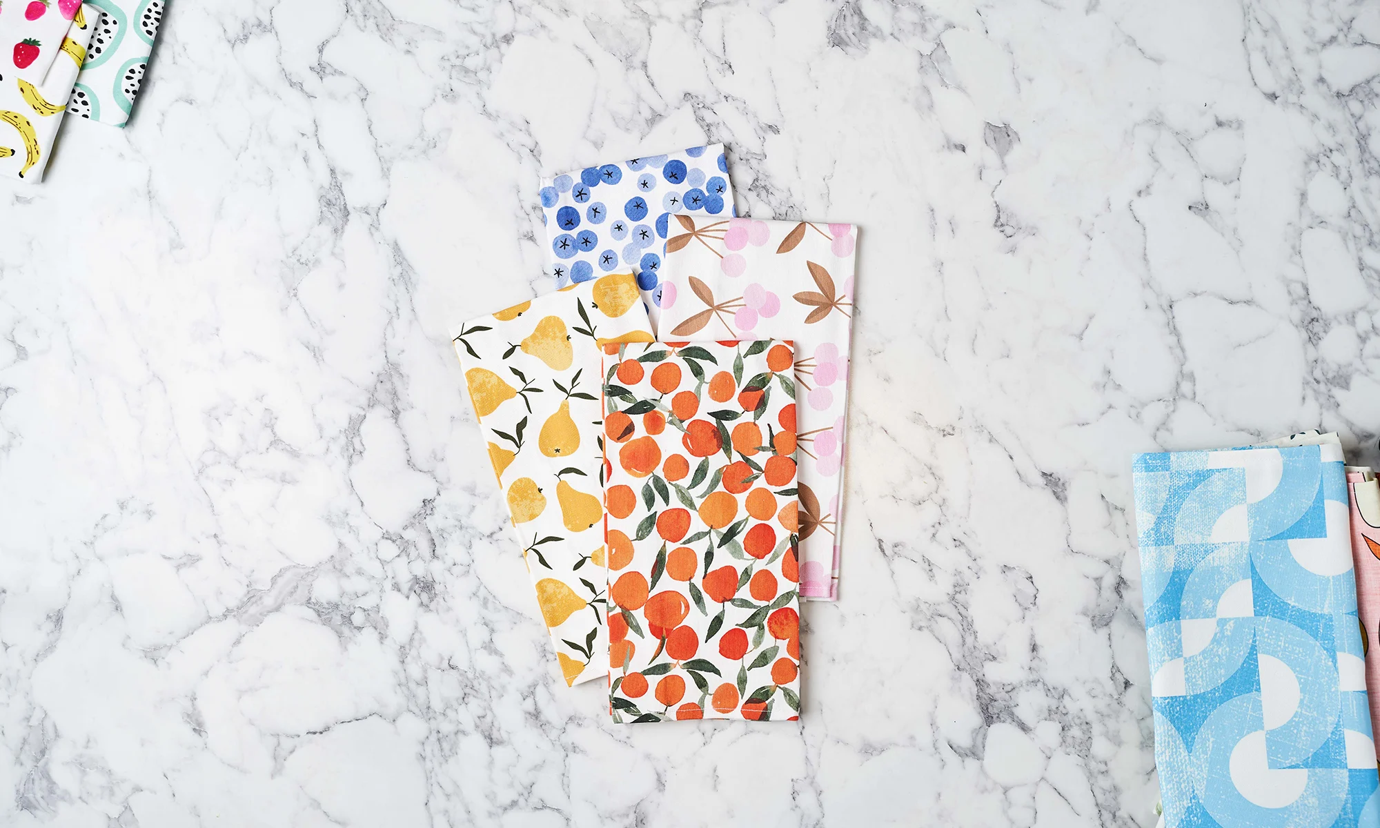Colorful fruit-themed tea towels on counter.