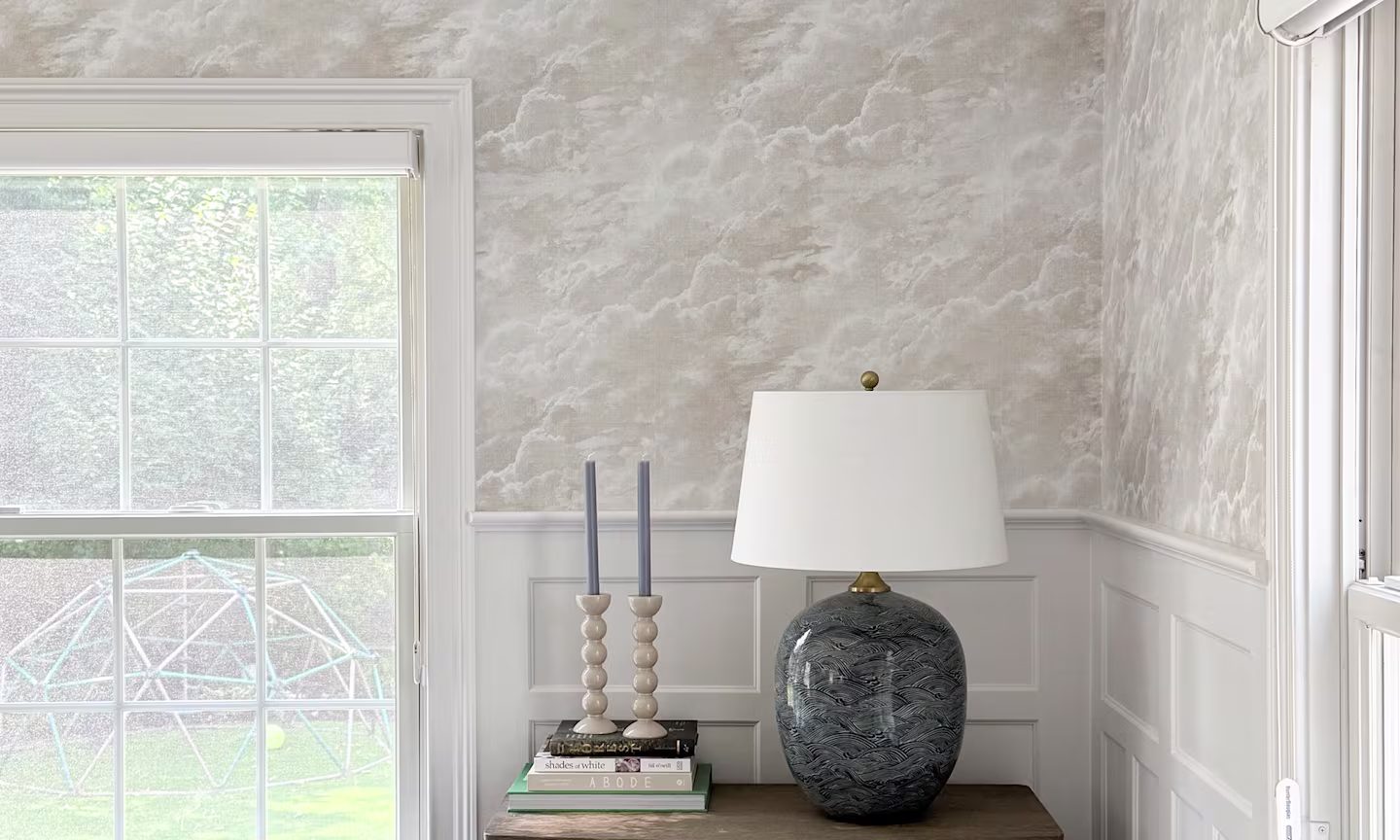living area with a grey and white cloud wallpaper.