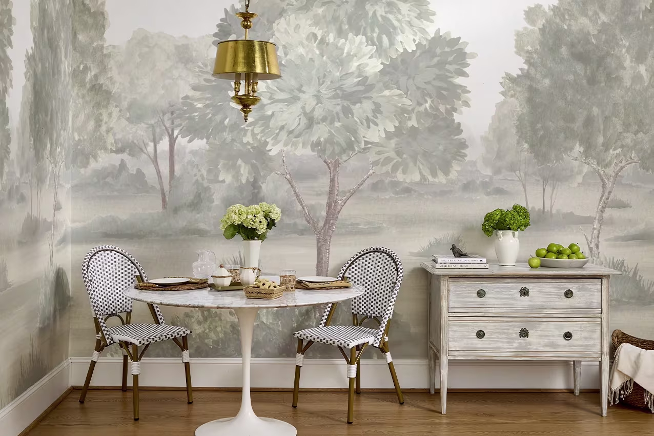 Dining nook featuring a misty landscape mural in bold olive that wraps seamlessly across two walls.