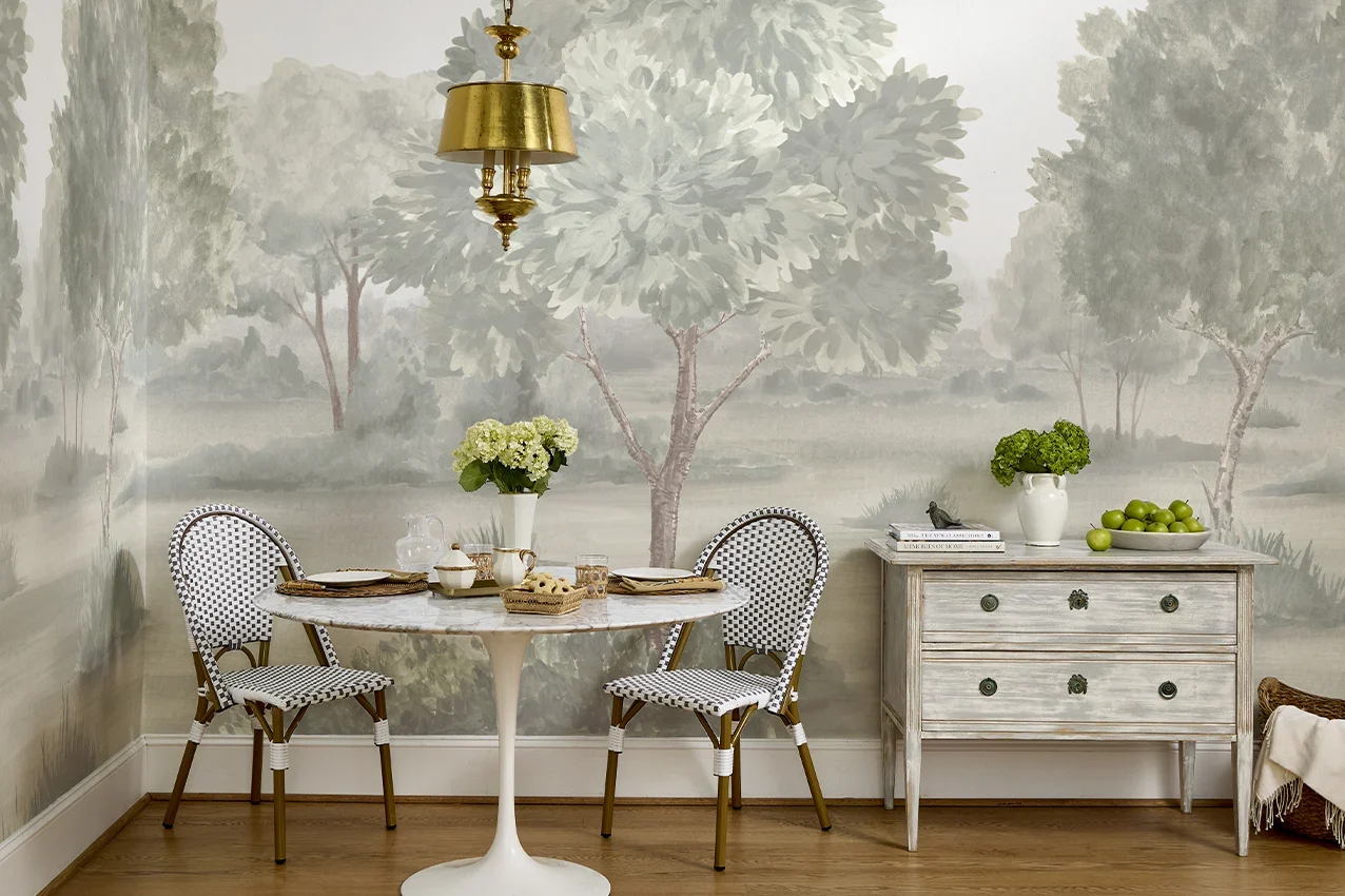 Dining nook featuring a misty landscape mural in bold olive that wraps seamlessly across two walls.