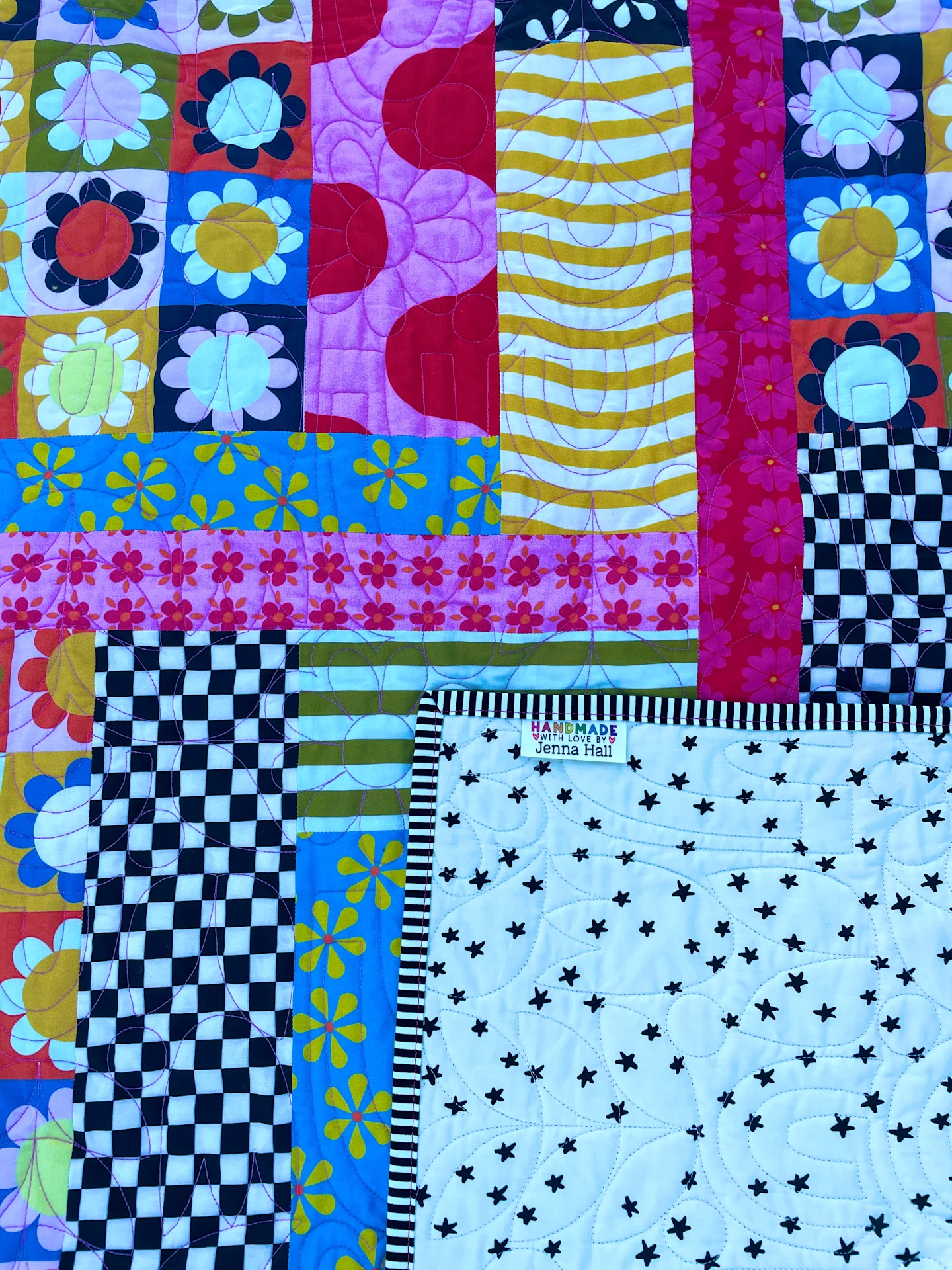 A closeup of Jenna Hall's finished quilt showing the quilt backing and label