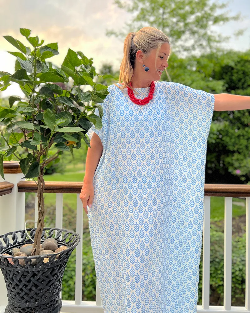 Danika holds up an arm in the caftan to show its straight wide side.