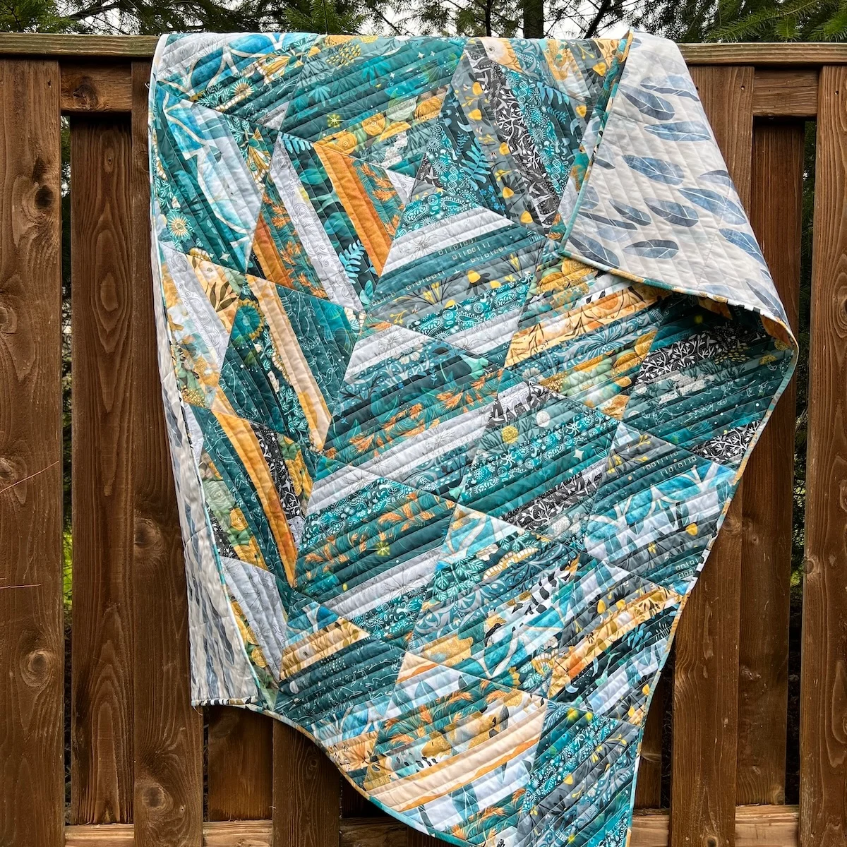 A teal and yellow quilt made with organic cotton sateen