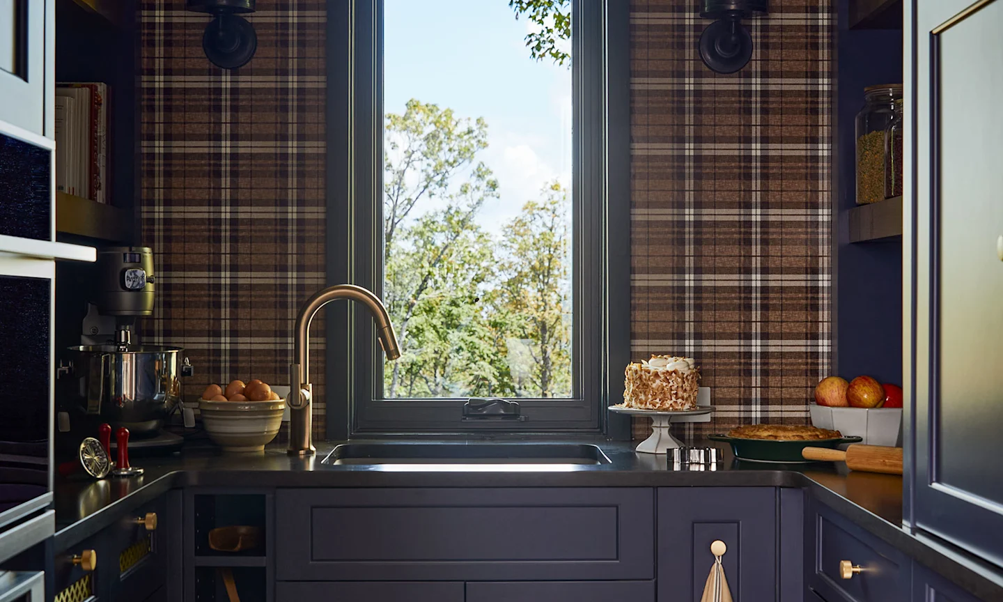 A kitchen with a brown plaid wallpaper.