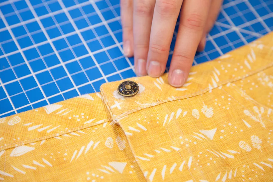 A close up of the denim button in the place where the hole was created.
