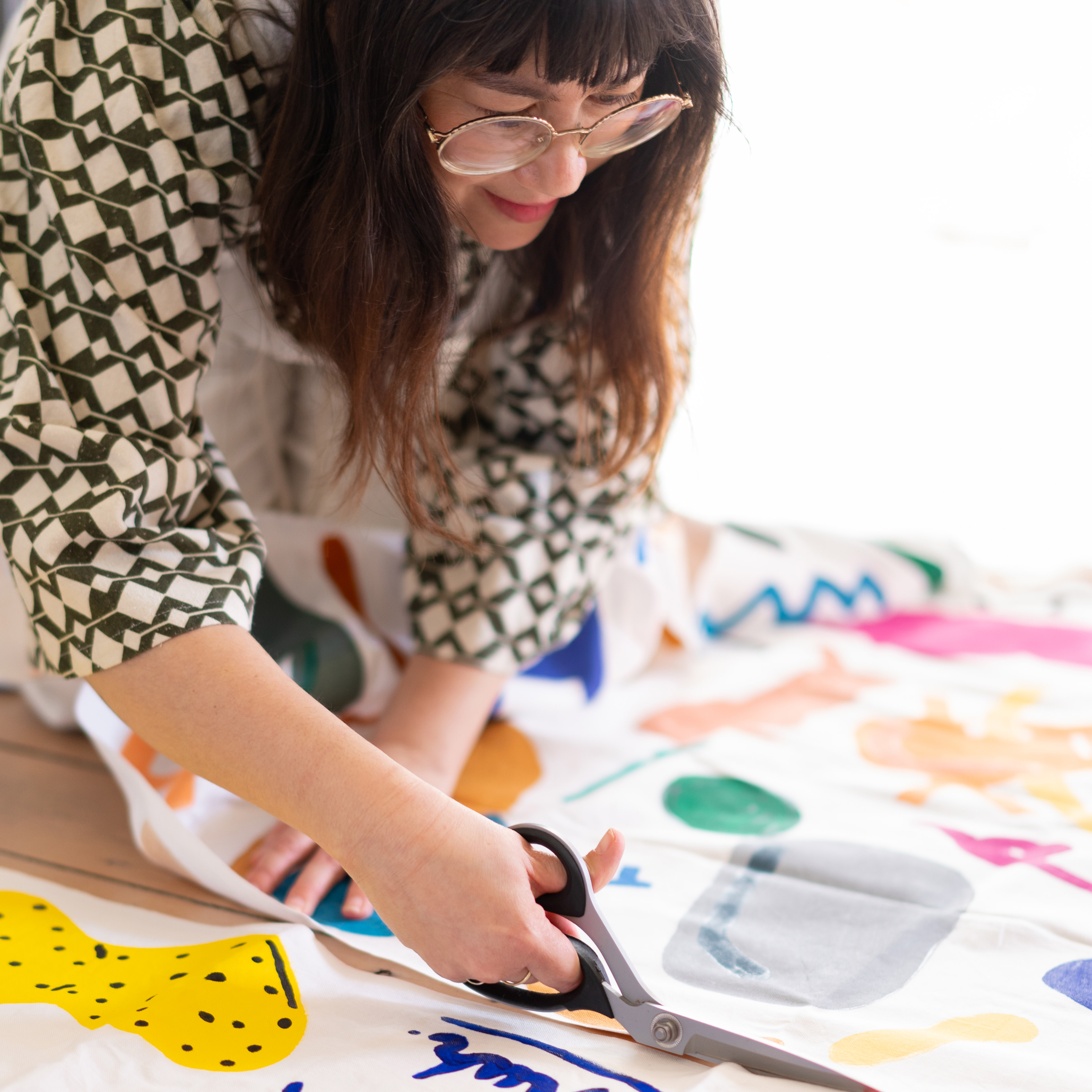 Person cutting fabric with shears