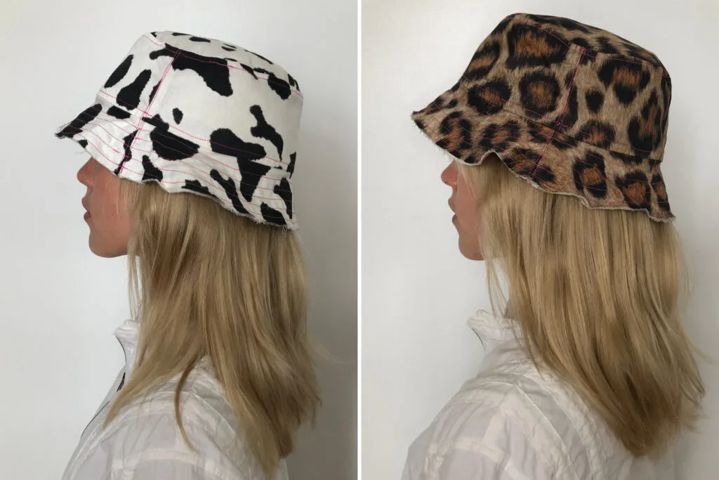 Person wearing bucket hat to show cow print and leopard print reversible sides