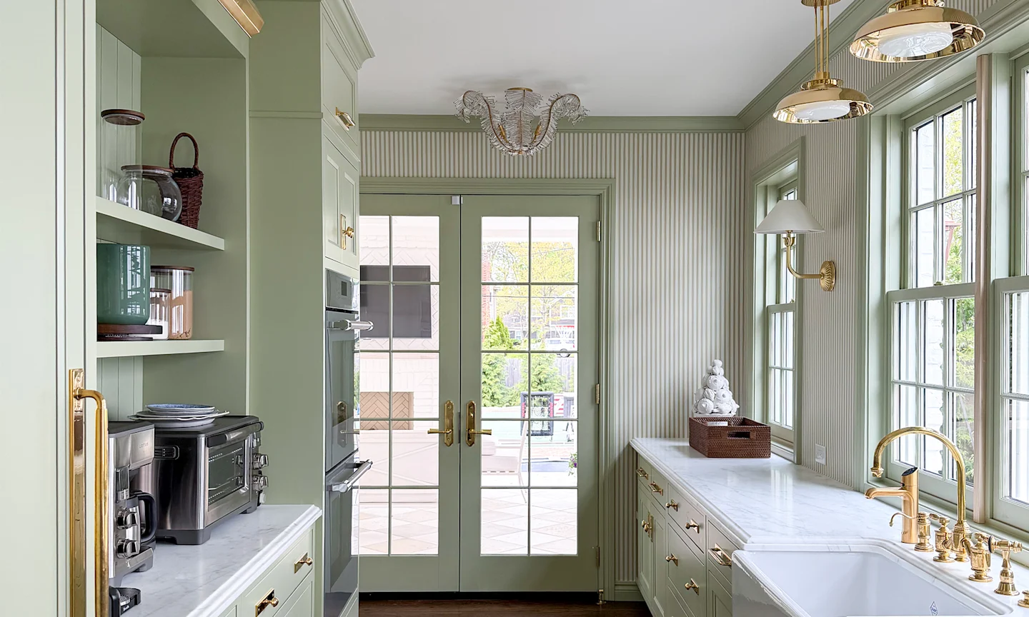 Kitchen with sage pinstripe wallpaper, green cabinetry dna marble countertops.