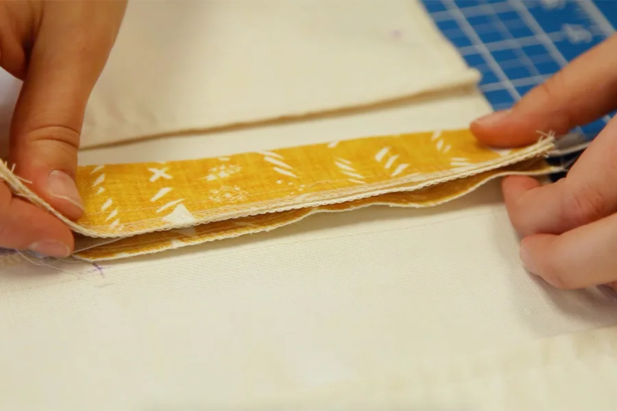 A close up of the fly extension with the zipper in between it. MaryAshlynn holds both sends of the fly extension to position it.