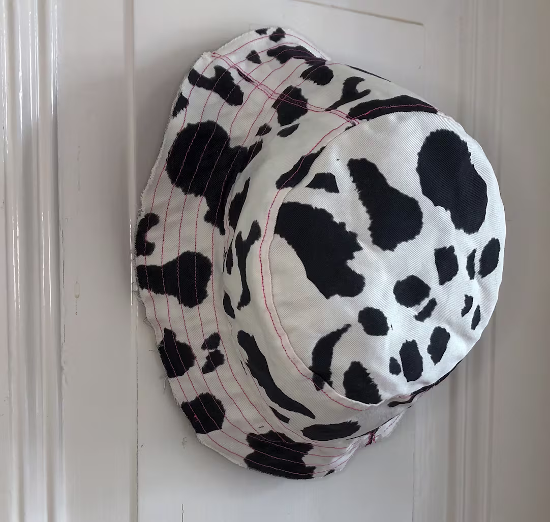 Cow print bucket hat hanging on a hook
