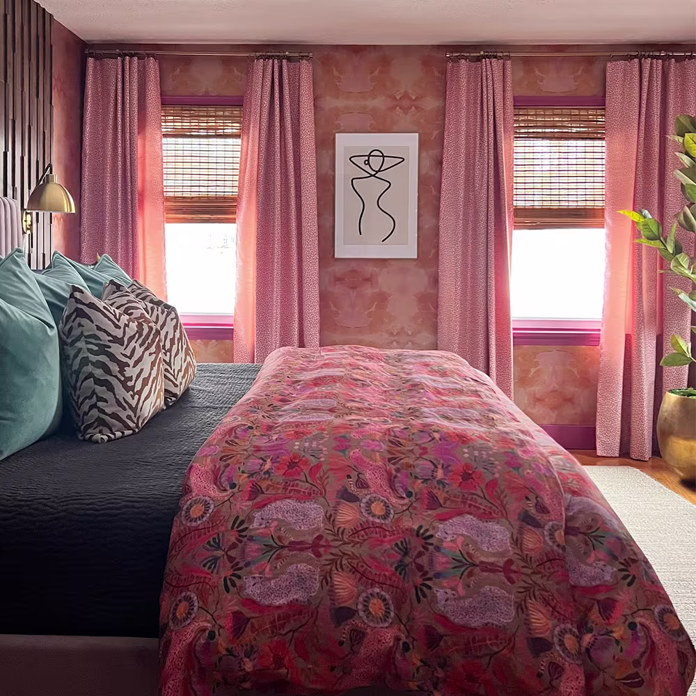 Bedroom with pink abstract wallpaper and bedding.