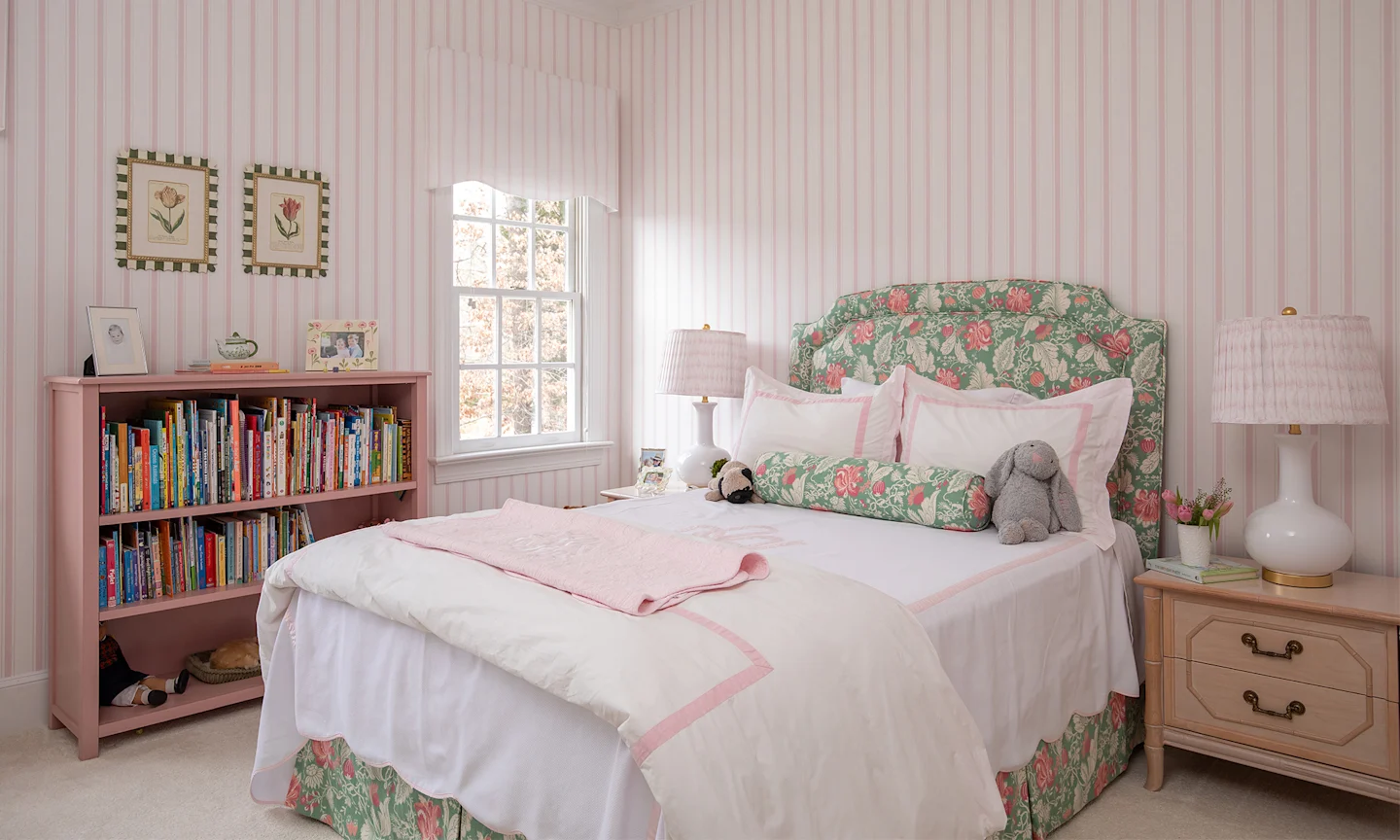 Girls bedroom with pink striped wallpaper and coordinating decor.