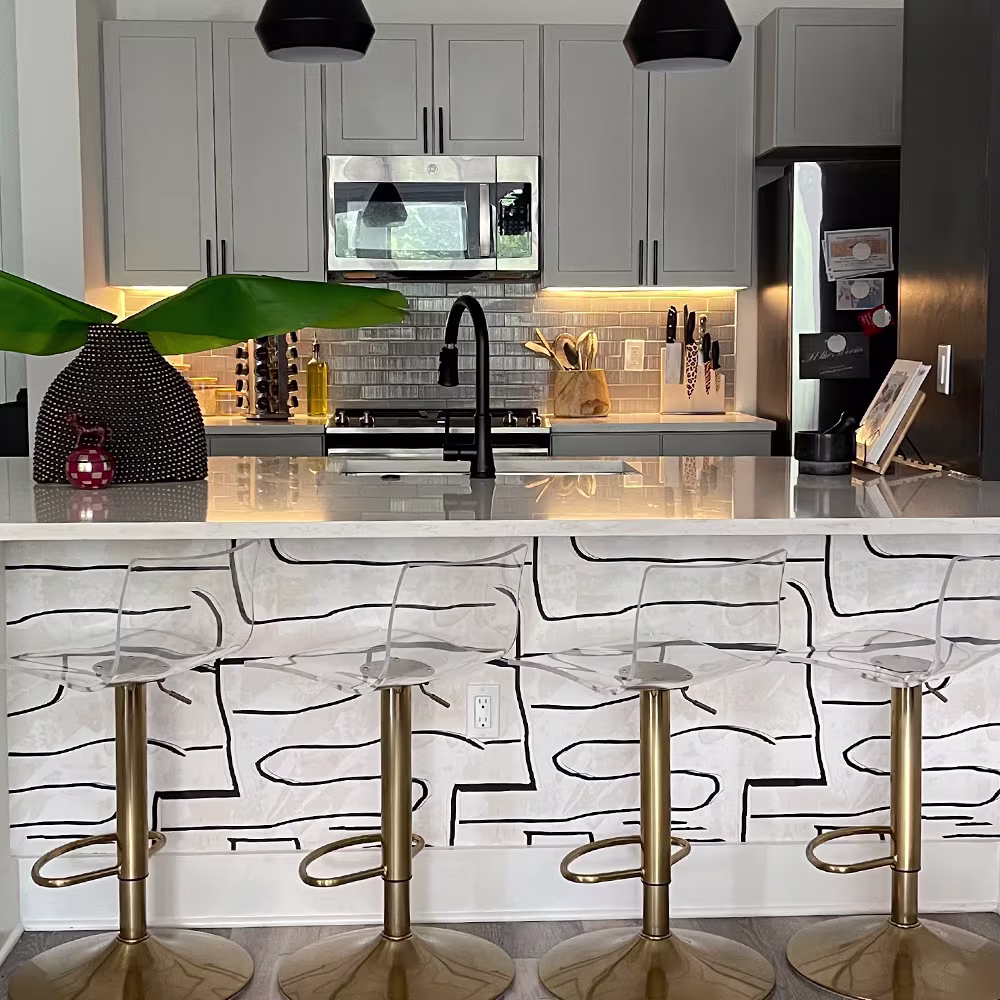 Black and white wallpaper on the side of a kitchen island.