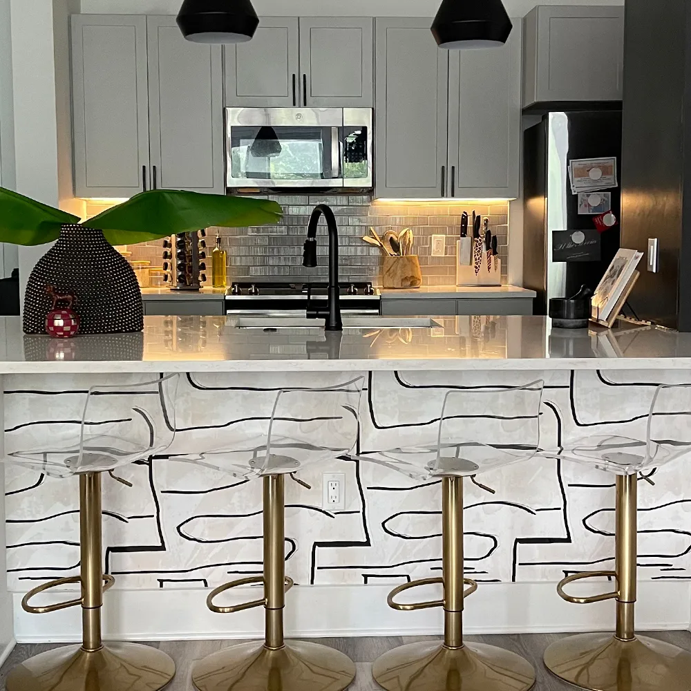 Black and white wallpaper on the side of a kitchen island.
