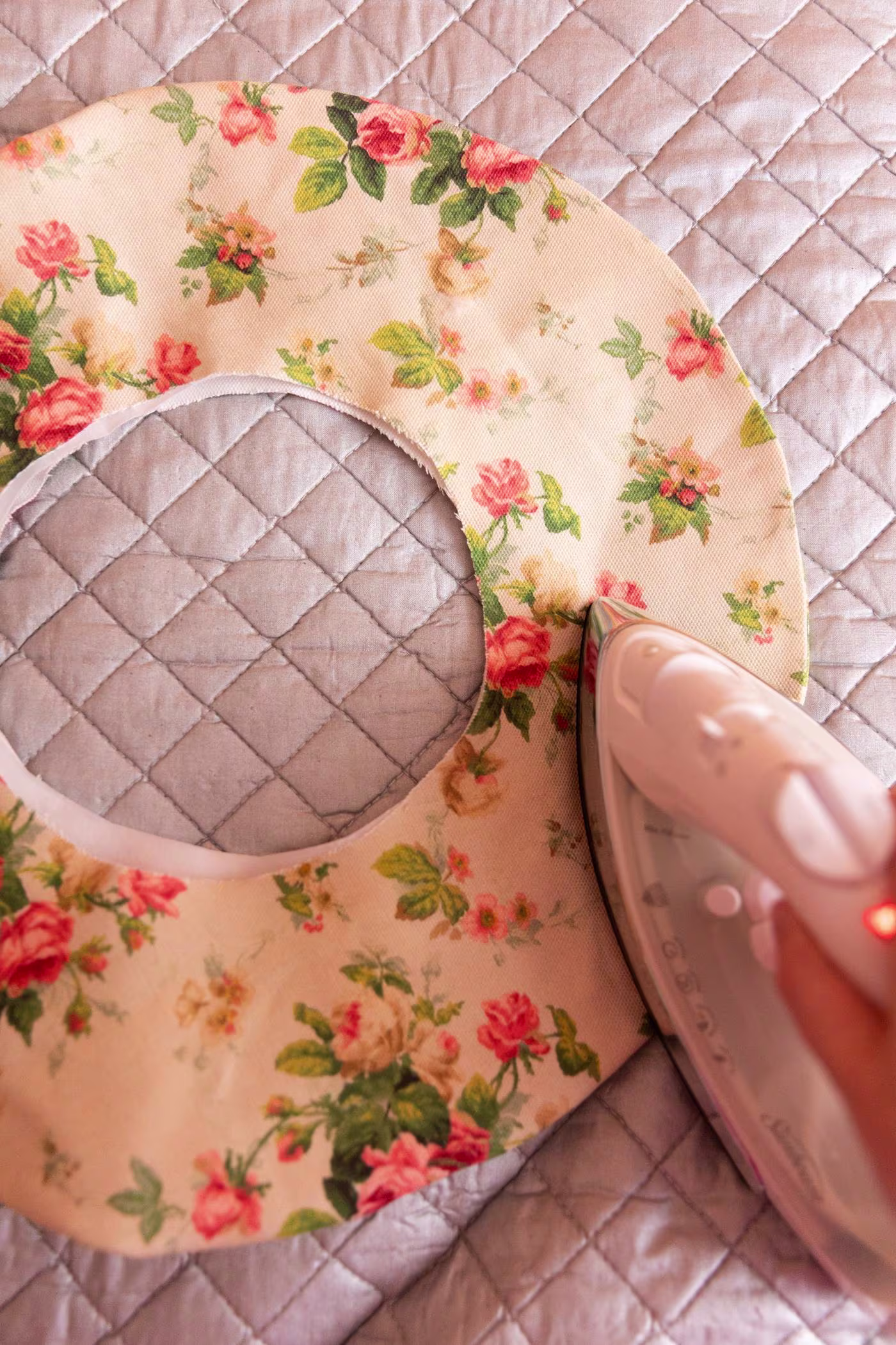 Keiko irons the brim, with the floral design side up, on a silver ironing mat.