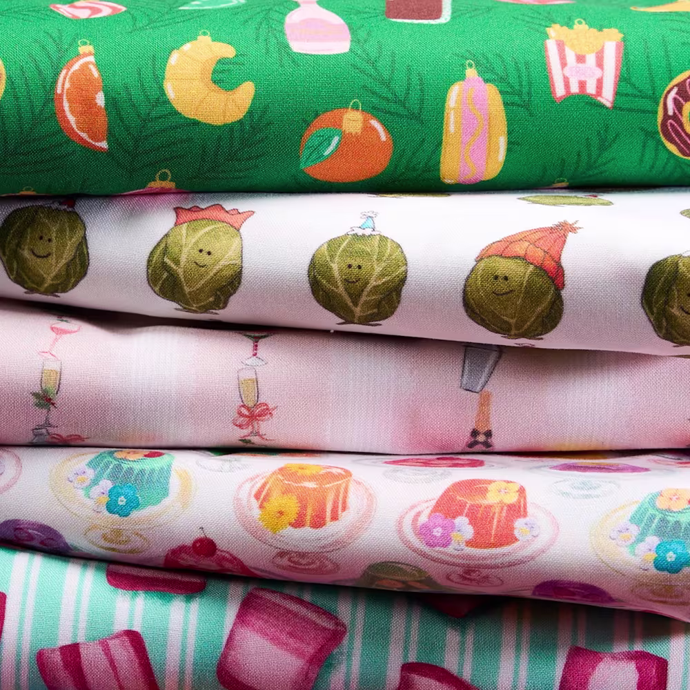 Stack of festive food design fabric on fleece fabric.