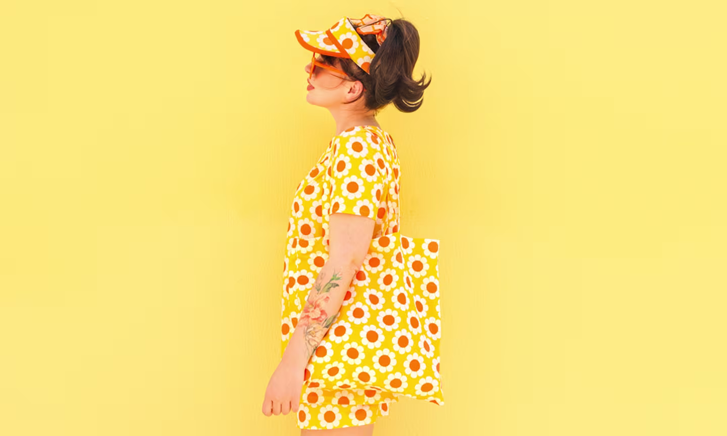 Keiko lynn in a yellow floral outfit against a yellow wall.