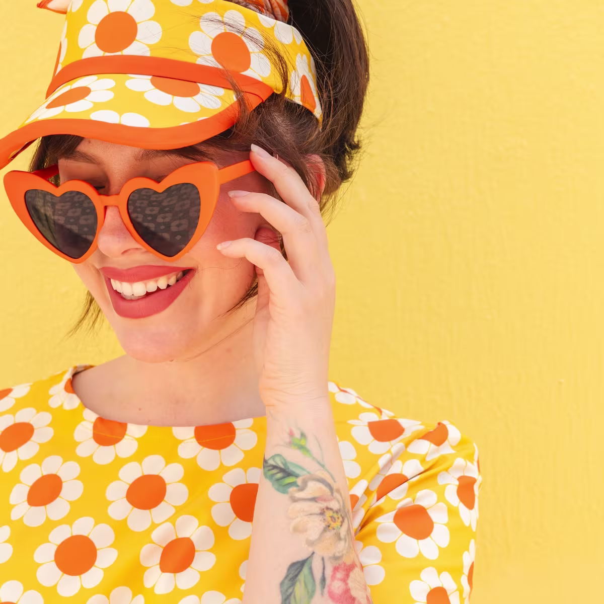 Keiko Lynn wearing a yellow retro floral dress with coordinating visor made with Sport Stretch Woven