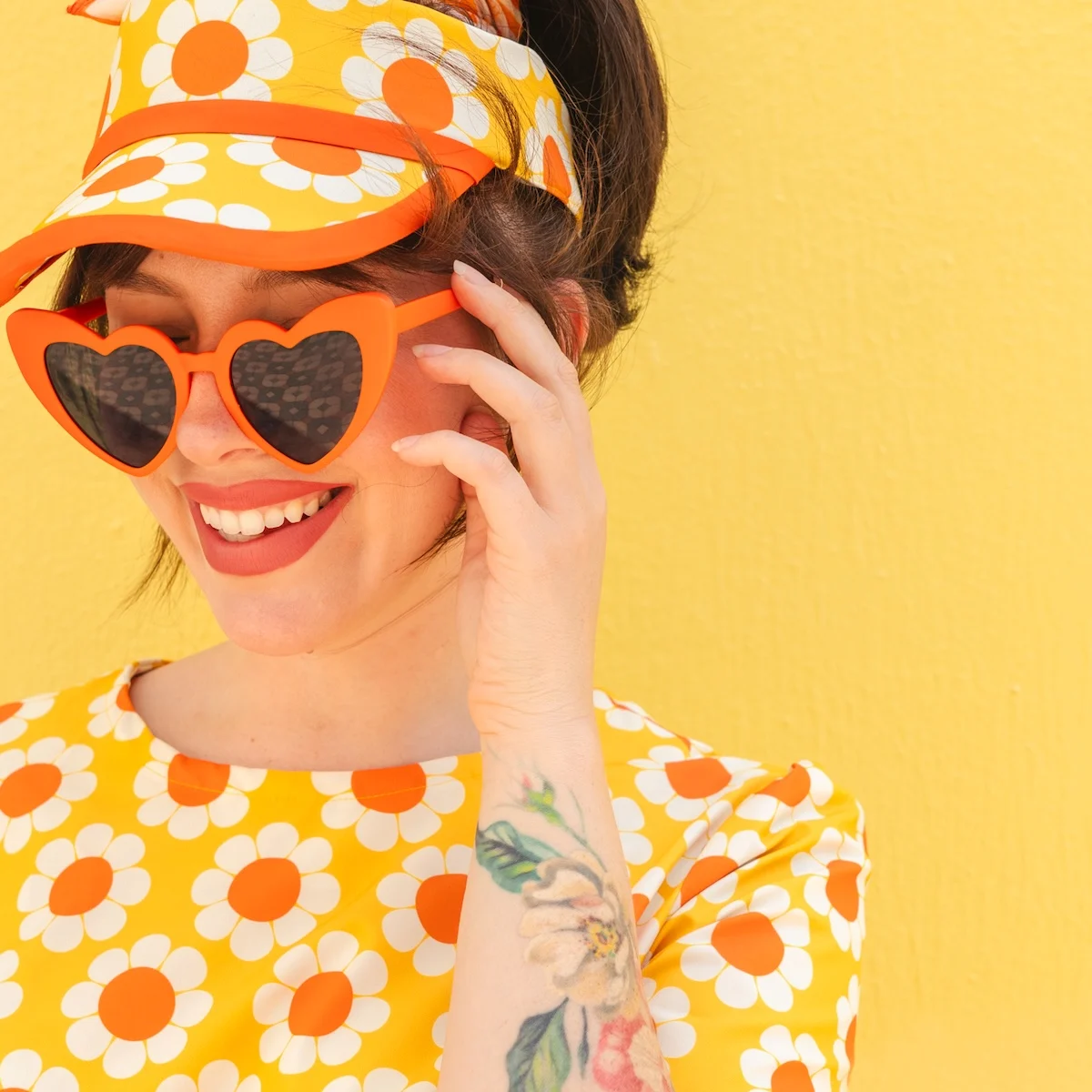 Keiko Lynn wearing a yellow retro floral dress with coordinating visor made with Sport Stretch Woven