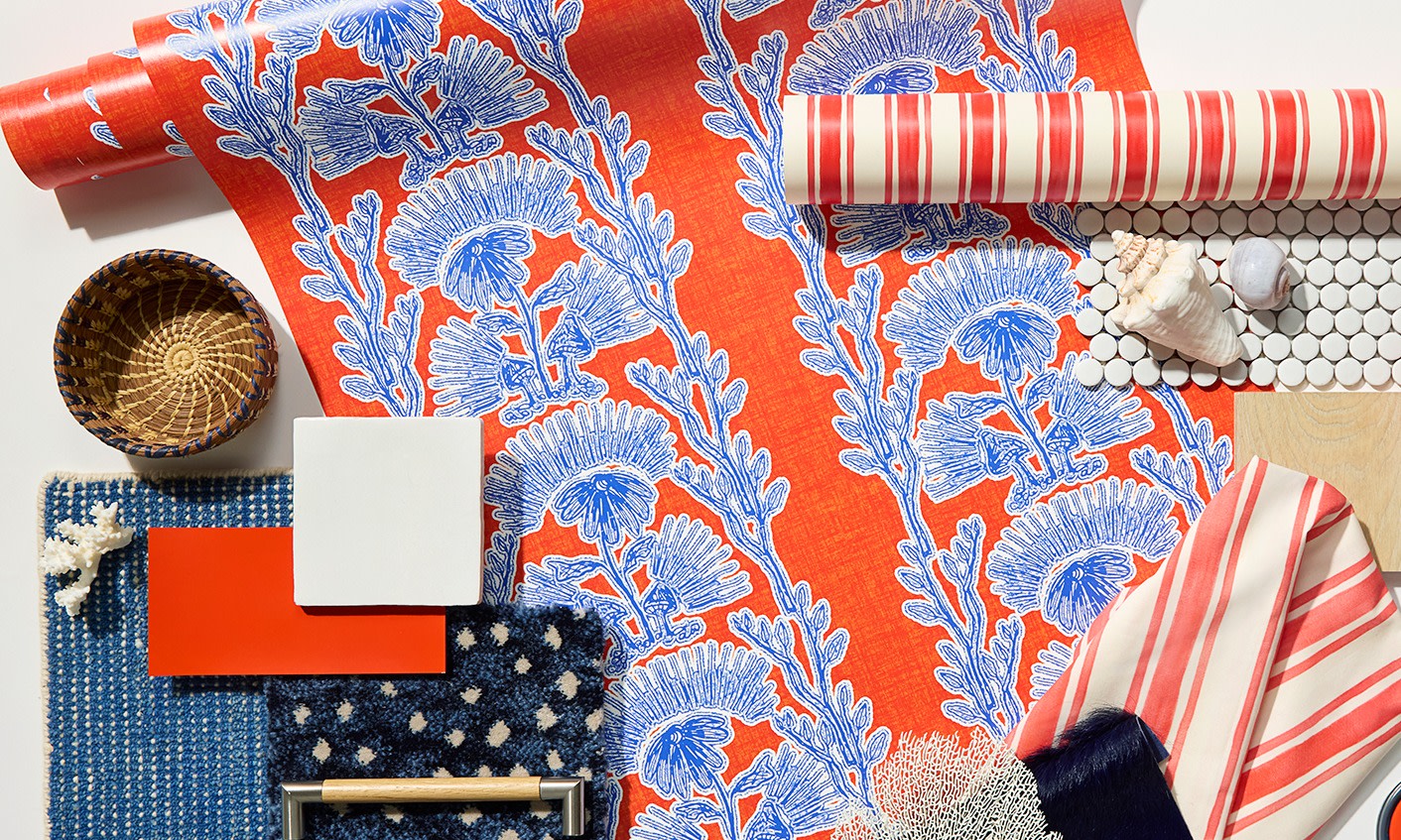 Rolls of red wallpaper on a white background with interior design items.