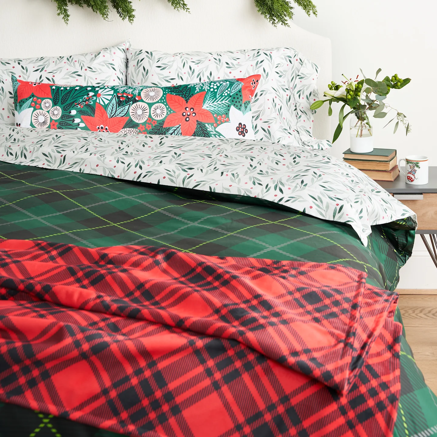 a holiday bed featuring a red plaid throw blanket