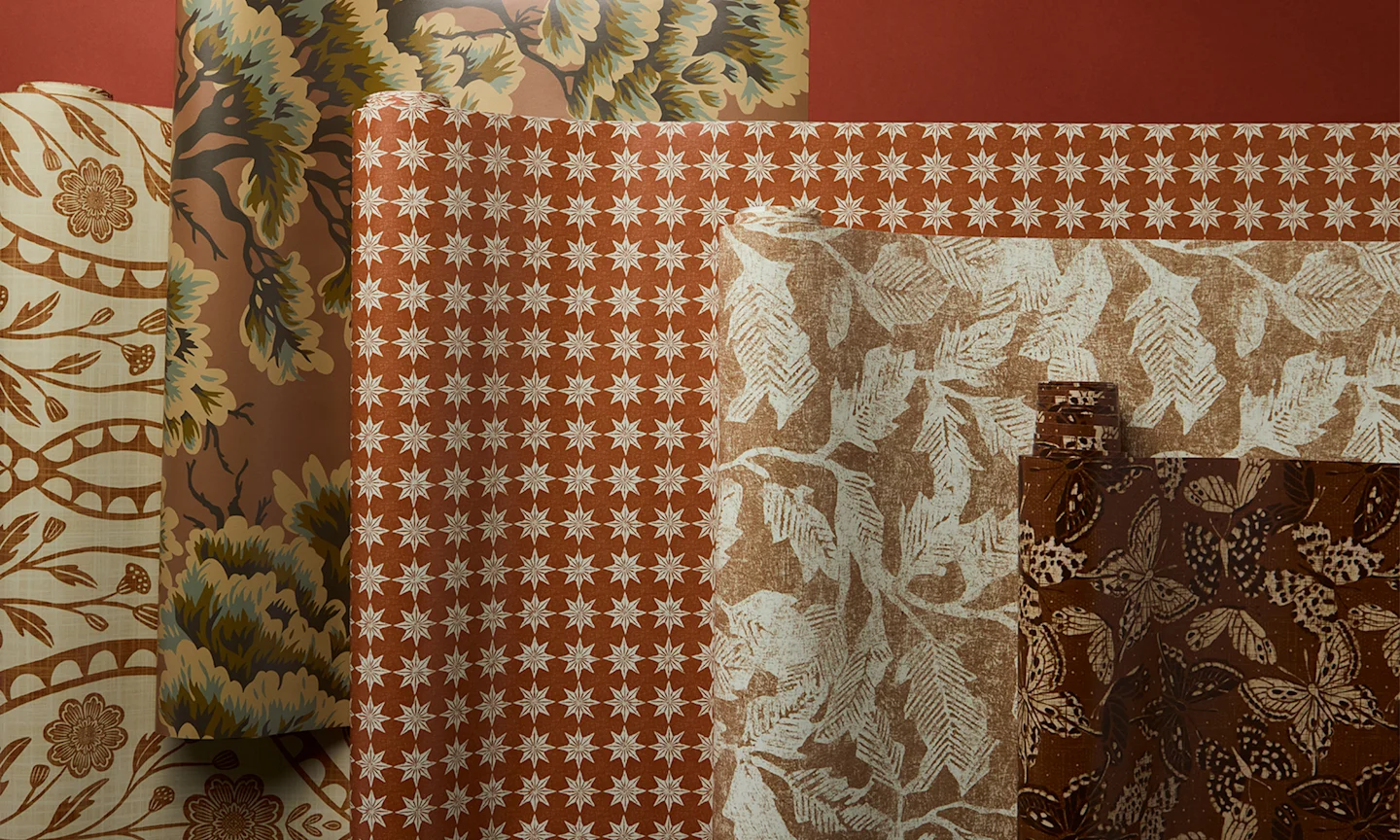 Rolls of terracotta red wallpapers.