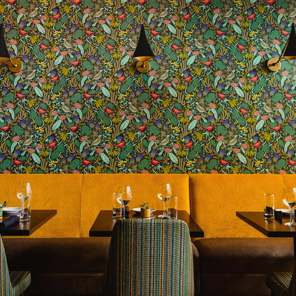 The Mayton Hotel's restaurant with floral wallpaper.