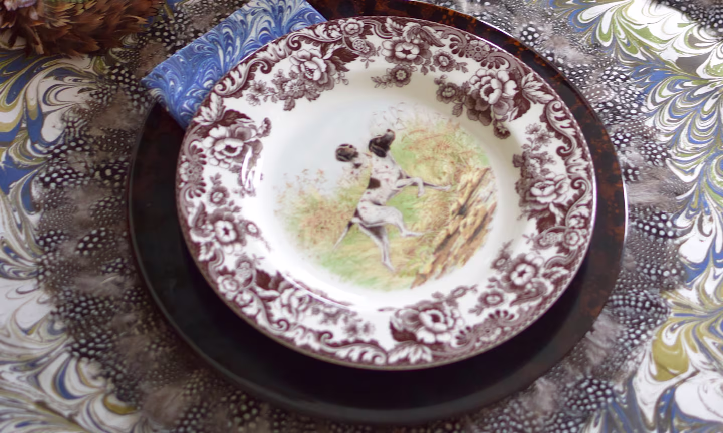 Table with marbles tablecloth and ornate plate.