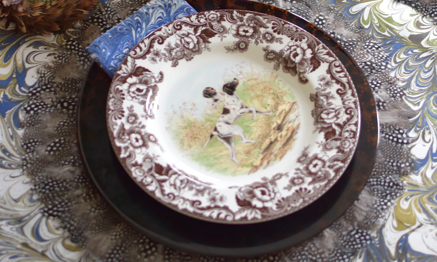 Table with marbles tablecloth and ornate plate.