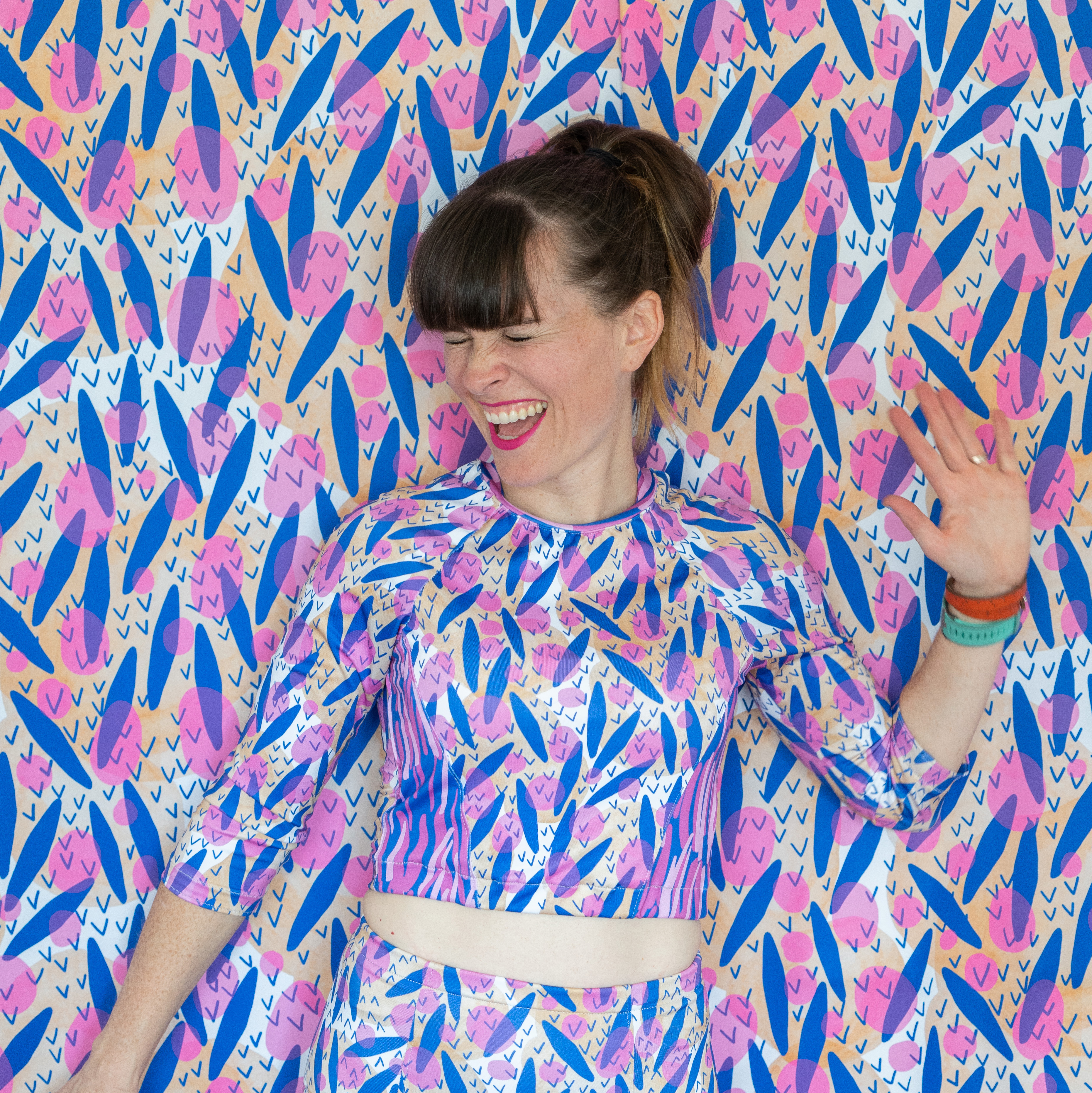 Person in outfit that perfectly matches wallpaper