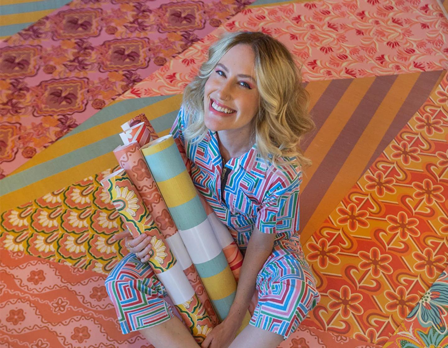 Dani Dazey holding rolls of Spoonflower wallpaper.